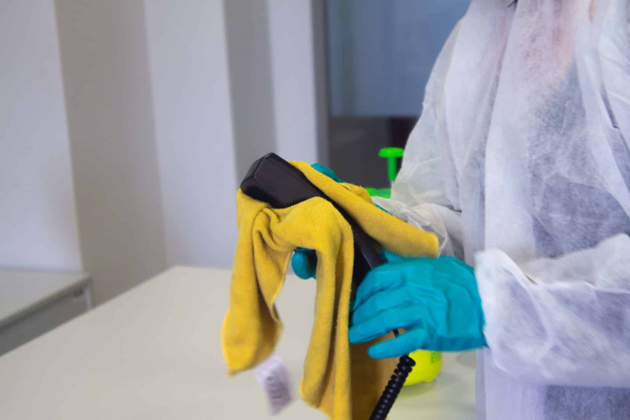 tecnico sanifica un telefono con areosol